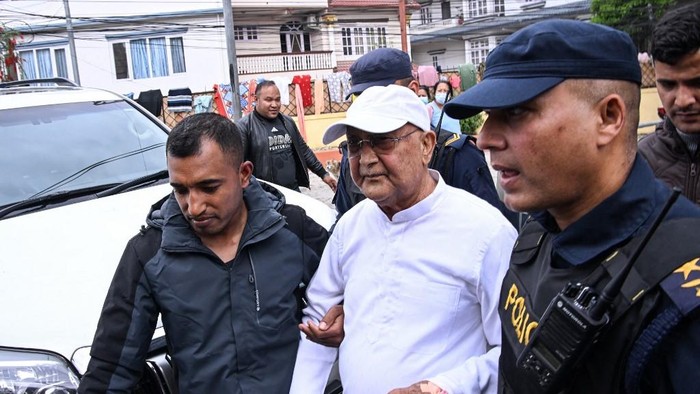 Mantan PM Nepal KP Sharma Oli dikawal polisi usai ditangkap pada Sabtu (28/3) waktu setempat (AFP/PRAKASH MATHEMA)