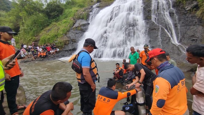 Petugas TRC BPBD Jepara bersama tim SAR gabungan saat mengevakuasi dua wisatawan yang tenggelam di air terjun Watu Bobot, Desa Somosari, Kecamatan Batealit, Jepara, Sabtu (28/3/2026).