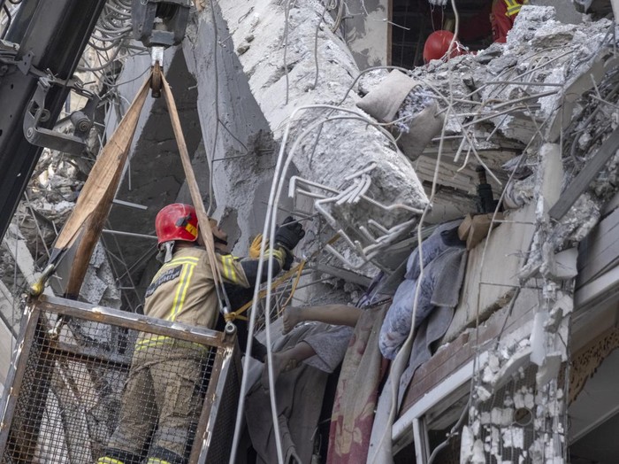 Iranian firefighters work to recover the body of an Afghan woman from the ruins of a residential building in Tehran, Iran, on March 27, 2026. The building was struck during a military operation involving the United States and Israel. (Photo by Morteza Nikoubazl/NurPhoto via Getty Images)