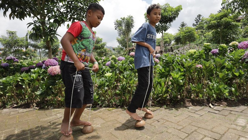 Sejumlah anak bermain egrang di Dusun Kuliner, Kota Batu, Jawa Timur, Minggu (29/3/2026). Permainan tradisional tersebut sebagai salah satu kegiatan positif bagi anak untuk mengurangi ketergantungan terhadap media sosial seiring diberlakukannya Peraturan Pemerintah Nomor 17 Tahun 2025 tentang Tata Kelola Penyelenggaraan Sistem Elektronik dalam Perlindungan Anak (PP Tunas). ANTARA FOTO/Prasetia Fauzani