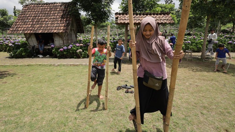 Sejumlah anak bermain egrang di Dusun Kuliner, Kota Batu, Jawa Timur, Minggu (29/3/2026). Permainan tradisional tersebut sebagai salah satu kegiatan positif bagi anak untuk mengurangi ketergantungan terhadap media sosial seiring diberlakukannya Peraturan Pemerintah Nomor 17 Tahun 2025 tentang Tata Kelola Penyelenggaraan Sistem Elektronik dalam Perlindungan Anak (PP Tunas). ANTARA FOTO/Prasetia Fauzani