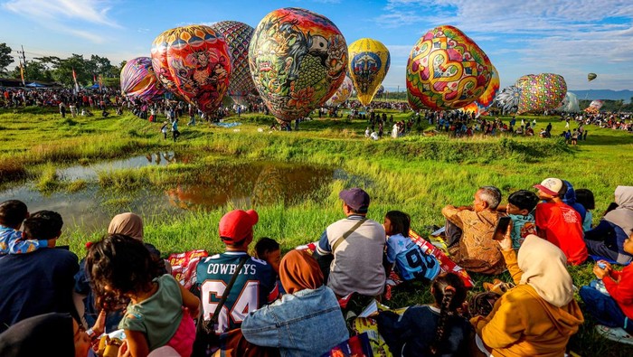 Sejumlah warga menyaksikan penerbangan balon udara di Sirkuit Motocross Ponorogo, Jawa Timur, Minggu (29/3/2026). Pemerintah Kabupaten Ponorogo menggelar Reog Balon Carnival yang diikuti 44 kelompok peserta dengan menerbangkan balon udara yang telah ditambatkan pada tanah bertujuan sebagai ajang promosi wisata dan budaya di kawasan tersebut sekaligus untuk menertibkan balon udara agar tidak diterbangkan secara liar yang dapat mengganggu lalu lintas udara. ANTARA FOTO/Muhammad Mada