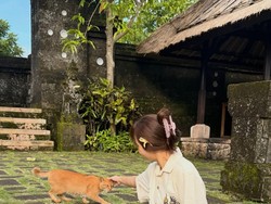 Lisa mengenaan kamen batik saat liburan di Bali. Ia bahkan mengelus dan memangku kucing oranye. Foto: (lalalalisa_m/Instagram)