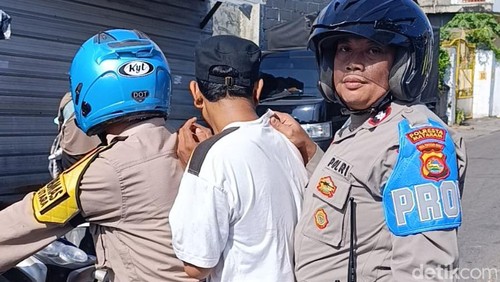 Polisi mengamankan AS (tengah) dari amukan massa setelah tepergok hendak mencuri di Pasar Kebon Roek Ampenan, Mataram, NTB, Minggu (29/3/2026). (Foto: Dok Polresta Mataram)