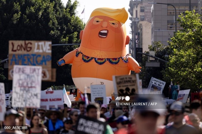 A giant inflatable balloon in the likeness of US President Donald Trump as a baby in diapers is seen as demonstrators march during the No Kings national day of protest in Los Angeles on March 28, 2026. Nationwide protests against US President Donal