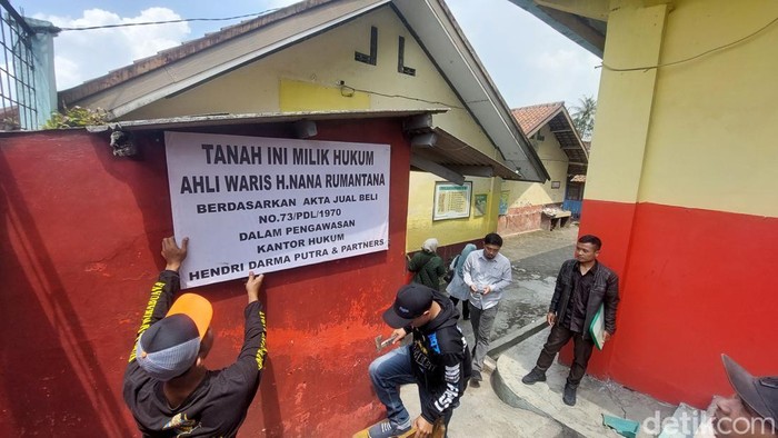 Ahli waris memasang plang pemberitahuan kepemilikan lahan tempat SD di KBB berdiri