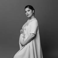 Pemotretan kehamilan lainnya masih dalam nuansa hitam-putih, namun Annisa tampak lebih glamor. Mantan model dan aktris ini memakai maxi dress berhias bordir. Rambutnya disanggul bergaya modern dan dipercantik aksesori seperti anting dan cincin. Foto: Instagram/@annisayudhoyono