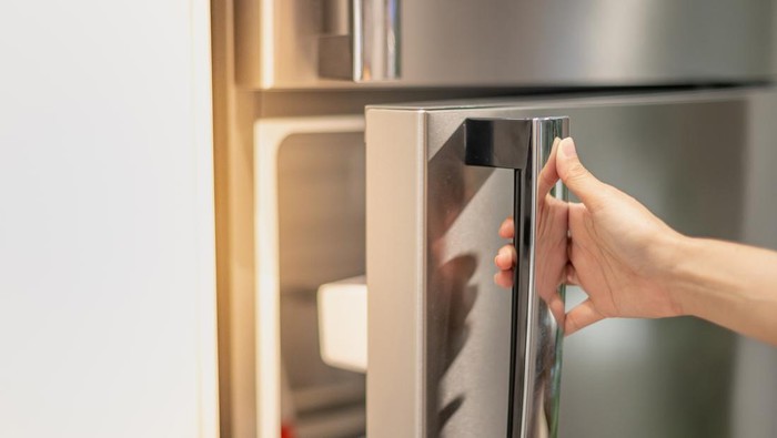Female hand opening a refrigerator door for find the food and ingredient preparing to cooking in their home.