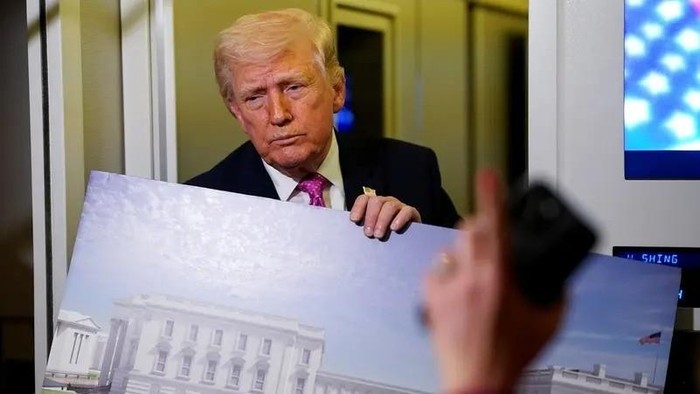 A member of the media raises her hand for a question as U.S. President Donald Trump talks while holding up renderings of the planned White House ballroom, aboard Air Force One en route to Joint Base Andrews, Maryland, U.S., March 29, 2026. (Reuters)