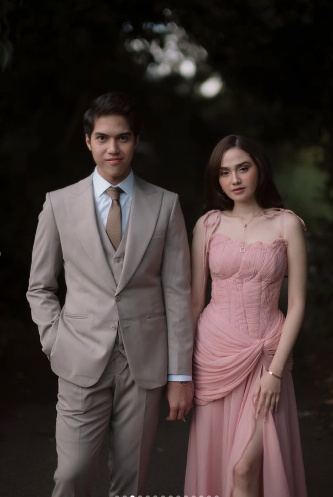 El tampil rapi dengan setelan jas berwarna beige yang memberi kesan clean dan sophisticated. Potongan jasnya pas di badan, memberikan siluet yang tegas dan maskulin. Rambutnya ditata rapi dengan gaya natural, memperkuat kesan gentleman. Foto: Instagram/@syifahadju/@elelrumi