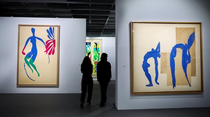 People walk past the painting 