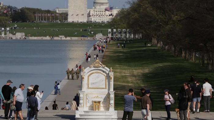 A statue featuring a large golden toilet, titled A Throne Fit for a King, is displayed near the Lincoln Memorial on the National Mall in Washington, D.C., U.S., March 30, 2026. REUTERS/Evelyn Hockstein