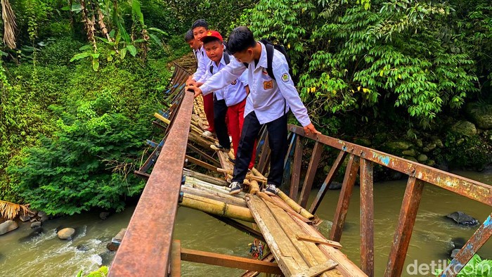 Pelajar Sukabumi saat melintasi jembatan melintir.