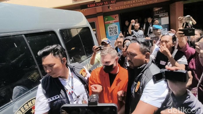 Steven Lyons saat digiring ke mobil tahanan di Mapolda Bali, Selasa (31/3/2026). (Dok. Abid Ahmad Ibrahim)