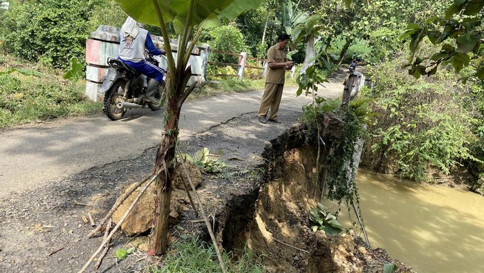 Talud atau sayap jembatan sungai widodaren longsor, ruas jalan menuju Desa Watesaji ikut amblas dan menghambat perjalanan warga. 