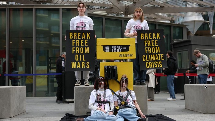 Demonstrators hold signs during a Fossil Free London protest over oil dependency, amid rising oil prices, as the U.S.-Israeli conflict with Iran continues, outside the U.S. Embassy in London, Britain, April 1, 2026. REUTERS/Hannah McKay