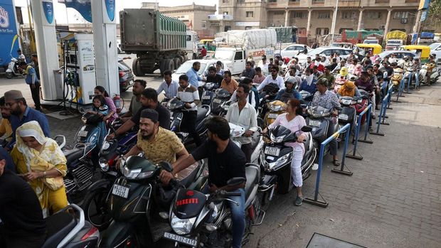Orang-orang mengantre untuk mengisi bensin kendaraan roda dua mereka dengan kekhawatiran akan potensi gangguan pasokan, tetapi pihak berwenang mengatakan tidak ada kekurangan, di tengah konflik AS-Israel yang sedang berlangsung dengan Iran, di Ahmedabad, India, 23 Maret 2026. (REUTERS/Amit Dave)