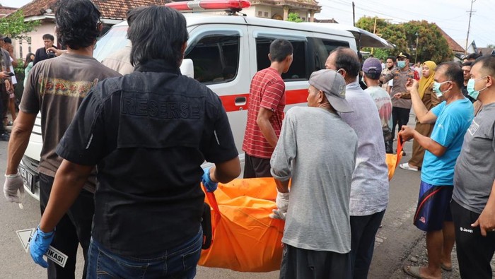 Polisi saat mengevakuasi jasad pria yang gantung diri di rumah