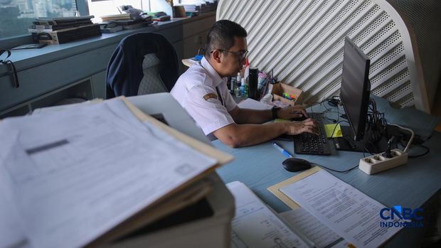 Sejumlah Aparatur Sipil Negara (ASN) menyelesaikan pekerjaannya di Gedung Balai Kota DKI Jakarta, Rabu (1/4/2026). (CNBC Indonesia/Faisal Rahman)