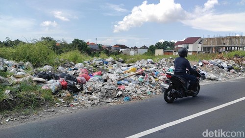 Spanduk larangan buang sampah sudah dipasang DLHK Badung di lahan kosong yang dijadikan TPA liar di kawasan Merta Agung, Kerobokan Kelod, Badung, Rabu (1/4/2026). (Agus Eka/detikBali)