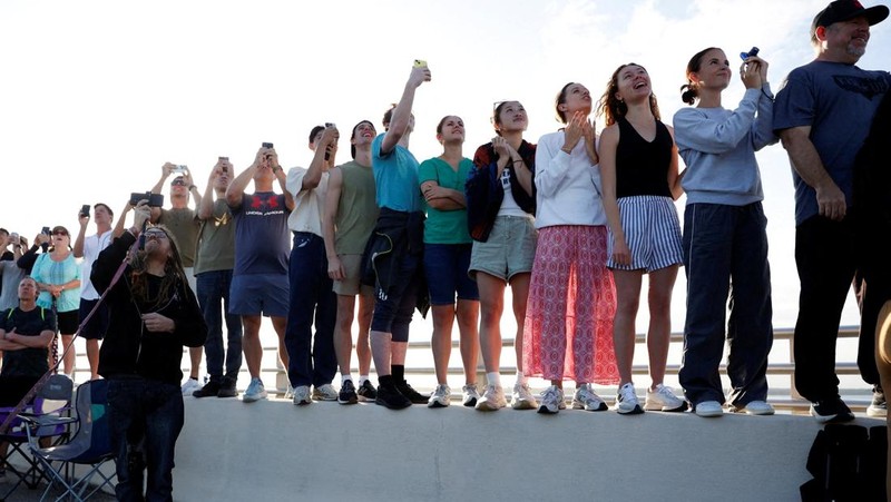 People gather on the day of the launch of the next-generation moon rocket, the Space Launch System (SLS) rocket and the Orion crew capsule, part of NASA's Artemis II lunar flyby mission, from NASA's Kennedy Space Center, in Titusville, Florida, U.S., April 1, 2026. REUTERS/Marco Bello     TPX IMAGES OF THE DAY