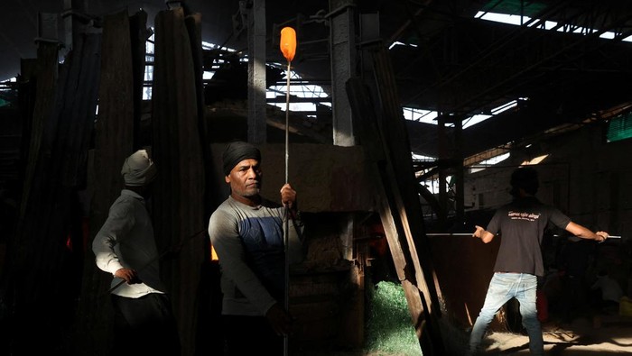 A worker checks the quality of bottles being manufactured inside a glass factory amid fuel supply disruptions following the U.S.-Israeli conflict with Iran, in Firozabad in the northern state of Uttar Pradesh, India, March 26, 2026. REUTERS/Bhawika Chhabra
