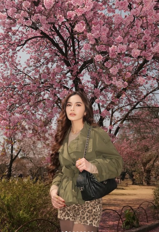 Pose dengan latar belakang bunga sakura, penampilan Mahalini satu ini tak kalah stylish. Ia memadukan jaket parka berwarna hijau dengan celana pendek motif leopard.  Foto: Instagram/@mahaliniraharja