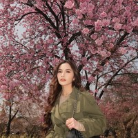 Pose dengan latar belakang bunga sakura, penampilan Mahalini satu ini tak kalah stylish. Ia memadukan jaket parka berwarna hijau dengan celana pendek motif leopard.  Foto: Instagram/@mahaliniraharja