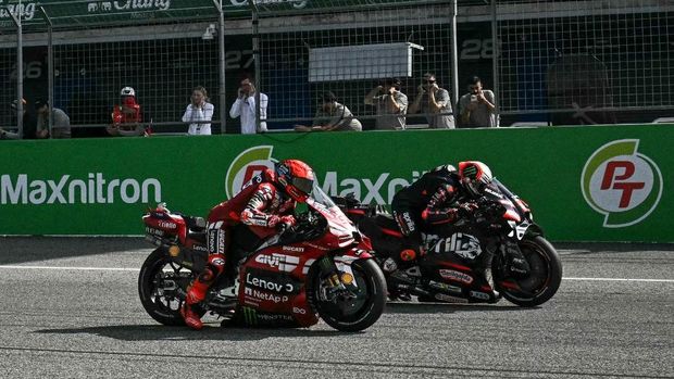 Ducati Lenovo Team's Spanish rider Marc Marquez (L) and Aprilia Racing's Italian rider Marco Bezzecchi (R) ride during the sprint race of the MotoGP Thailand Grand Prix at the Buriram International Circuit in Buriram on February 28, 2026. (Photo by Lillian SUWANRUMPHA / AFP)