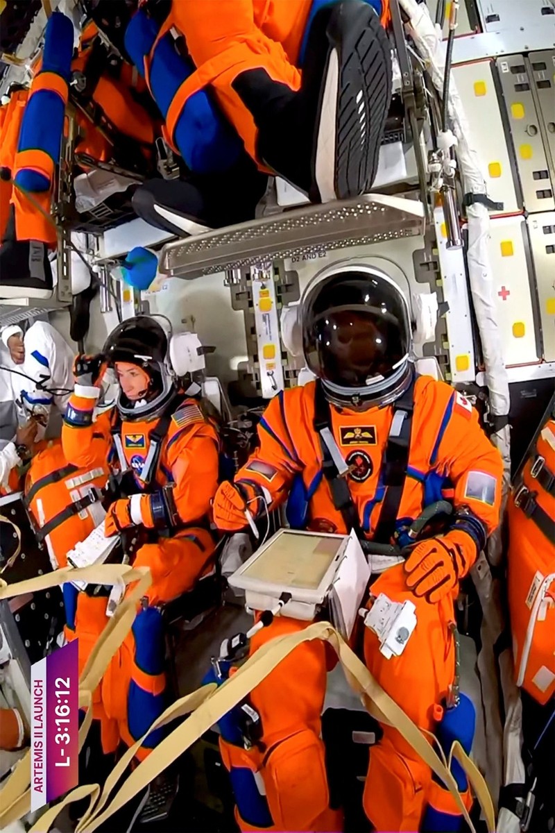 NASA astronaut Christina Koch adjusts her helmet visor next to CSA (Canadian Space Agency) astronaut Jeremy Hansen in the Orion crew capsule before the planned Artemis II launch mission to fly by the moon, at the Kennedy Space Centre in Cape Canaveral, Florida, U.S., April 1, 2026, in a still image from video.  NASA TV/Handout via REUTERS    THIS IMAGE HAS BEEN SUPPLIED BY A THIRD PARTY