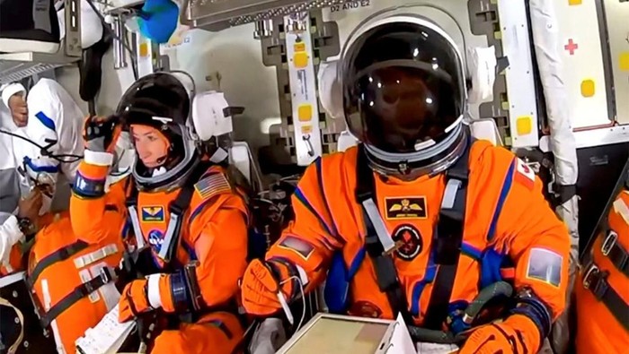 NASA astronaut Christina Koch adjusts her helmet visor next to CSA (Canadian Space Agency) astronaut Jeremy Hansen in the Orion crew capsule before the planned Artemis II launch mission to fly by the moon, at the Kennedy Space Centre in Cape Canaveral, Florida, U.S., April 1, 2026, in a still image from video.  NASA TV/Handout via REUTERS    THIS IMAGE HAS BEEN SUPPLIED BY A THIRD PARTY