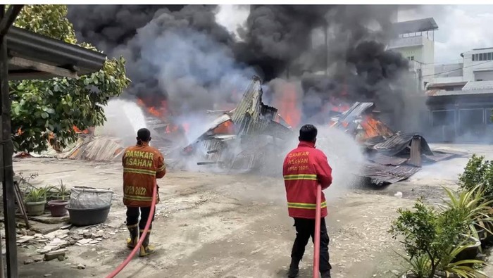 Petugas damkar saat berjibaku memadamkam api di gudang penitipan mobil di Asahan, Sumut. (dok. Damkar Asahan)