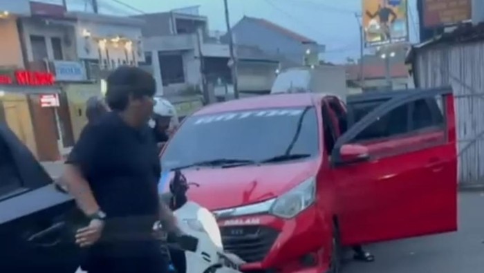 Polisi saat menyergap sebuah mobil merah yang diduga membawa obat keras ilegal