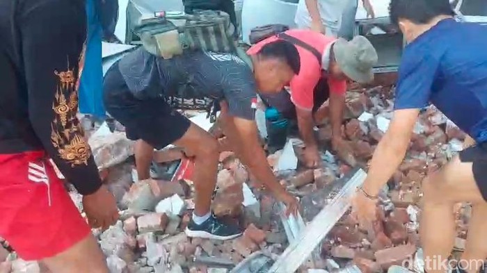 Warga melakukan evakuasi terhadap korban tertimpa bangunan dampak gempa di Bitung.