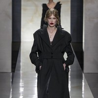 Peragaan ini menampilkan kembalinya esensi tailoring klasik melalui potongan presisi, siluet terstruktur, dan motif pinstripe berbahan wol. Namun, Dolce & Gabbana menghadirkan pendekatan inovatif dengan menempatkan detail double-breasted tidak hanya di bagian depan, tetapi juga di belakang jaket, menciptakan efek visual yang unik. (Foto: Victor VIRGILE/Gamma-Rapho via Getty Images)