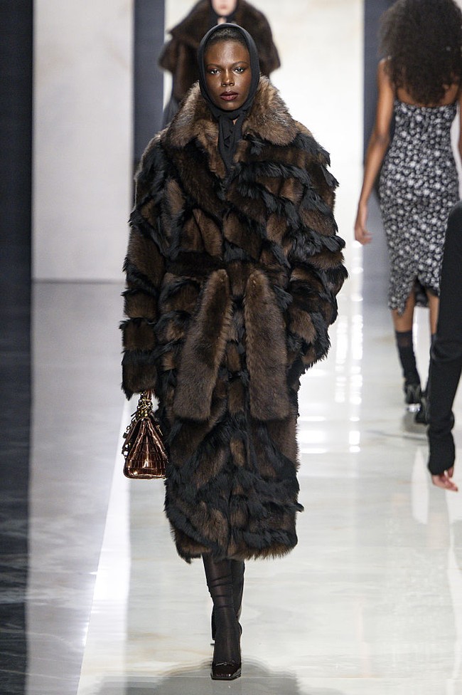 Dalam semangat keberlanjutan, koleksi ini menghadirkan outerwear tanpa bulu hewan. Jaket shearling diolah dengan teknik yang meniru gaya bulu klasik era 1930-an, seperti intarsia dan carving, namun tetap menggunakan material yang lebih etis. Siluetnya yang lembut dan bervolume menonjolkan lekuk feminin secara elegan. (Foto: Victor VIRGILE/Gamma-Rapho via Getty Images)