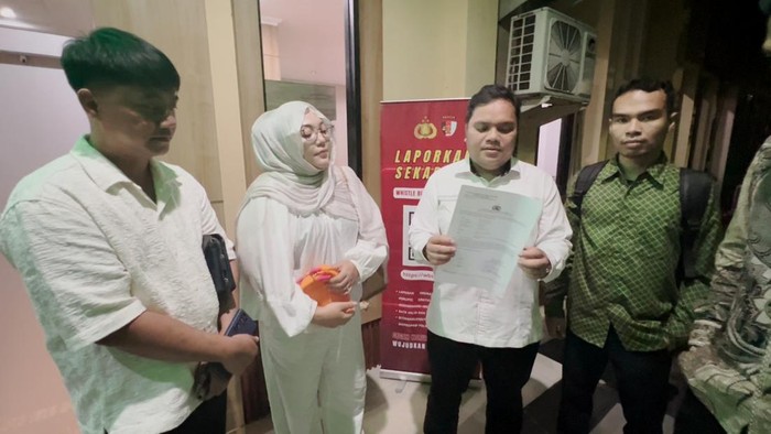 Nur Komariah didampingi keluarga dan tim pengacara saat melaporkan dugaan kasus ITE di SPKT Polda Jatim.