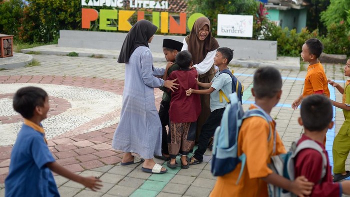Sejumlah anak membaca buku dongeng di Kampung Pekijing, Kota Serang, Banten, Sabtu (4/4/2026). Kegiatan lapak baca dan permainan tradisional yang rutin diselenggarakan pada Sabtu-Minggu dan diinisasi oleh pemuda setempat tersebut menjadi wujud nyata dukungan warga terhadap Peraturan Pemerintah (PP) Tunas terkait pembatasan media sosial pada anak, sekaligus dinilai efektif dalam menekan kecanduan gawai. ANTARA FOTO/Muhammad Bagus Khoirunas/YU