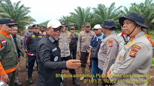 Kapolres Pelalawan AKBP John Louis Letedara dan Bupati H Zukri bersama Kapolsek Teluk Meranti Ipda Vicky Rizky memimpin pemadaman api, Sabtu (4/4/2026).