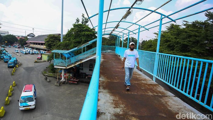 Warga melintas di jembatan penyeberangan orang (JPO) di kawasan Terminal Kampung Rambutan, Jakarta Timur, Sabtu (4/4/2026), yang kondisinya rusak dan memprihatinkan.