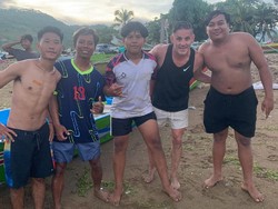 Sejumlah warlok tampak antusias berpose bersama pelatih Timnas Indonesia John Herdman di Pantai Kuta Mandalika. Pria asal Inggris itu beberapa kali dipanggil penggemar Timnas Indonesia di Lombok. (Foto: Facebook @Putra_Coy)