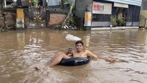 Pemuda di Banjar Tengah, Desa Mendoyo Dauh Tukad, Kecamatan Mendoyo, Kabupaten Jembrana saat bermain air banjir, Minggu (5/4/2026).