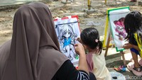 Sejumlah warga duduk di tepian kanal sambil bersantai bersama keluarga.