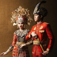 Kedua calon pengantin tampil kompak dalam balutan busana bernuansa merah. Busana adat tersebut semakin terlihat mewah dengan detail bordir dan ornamen emas. Foto: Instagram/@thebridestory