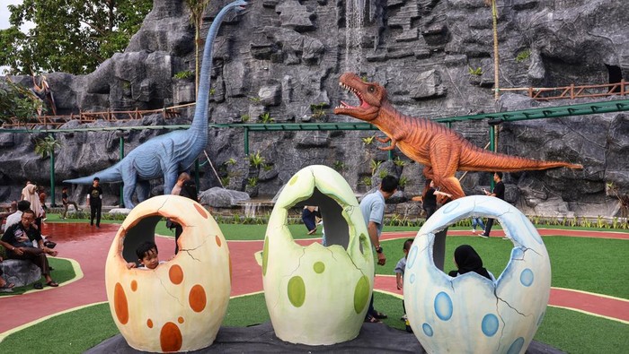 Pengunjung menikmati suasana taman dinosaurus di objek wisata Main Air di Kabupaten Gowa, Sulawesi Selatan, Minggu (5/4/2026). Objek wisata bernuansa taman dinosaurus yang dilengkapi berbagai wahana permainan tersebut menjadi tujuan wisatawan saat libur hari Paskah dan akhir pekan dengan jumlah kunjungan lebih dari 500 orang per hari. ANTARA FOTO/Arnas Padda/nym.