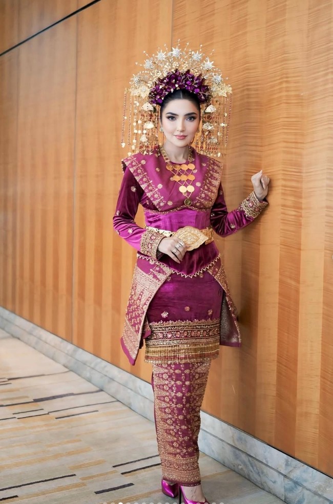 Kain yang dikenakan dihiasi motif khas songket Palembang berwarna emas. Motif ini terlihat rumit dan penuh detail, menambah kesan tradisional sekaligus eksklusif. Foto: Instagram/@viennagallery
