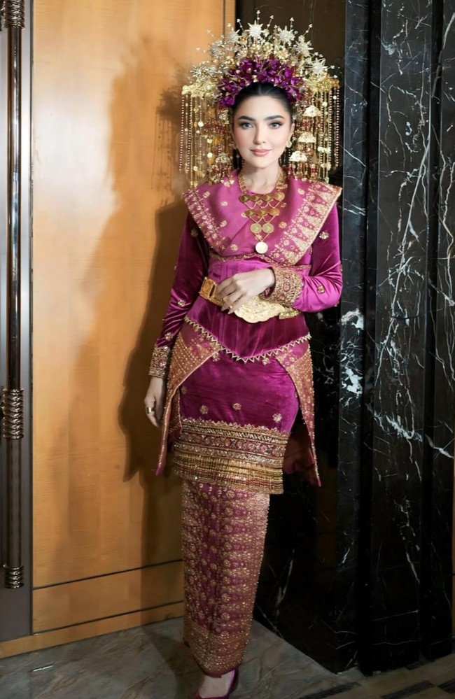 Mahkota suntiang yang dikenakan juga tak kalah jadi sorotan. Dengan hiasan bunga emas dan untaian ornamen menjuntai, suntiang tersebut memberikan kesan megah dan anggun khas pengantin adat. Foto: Instagram/@viennagallery