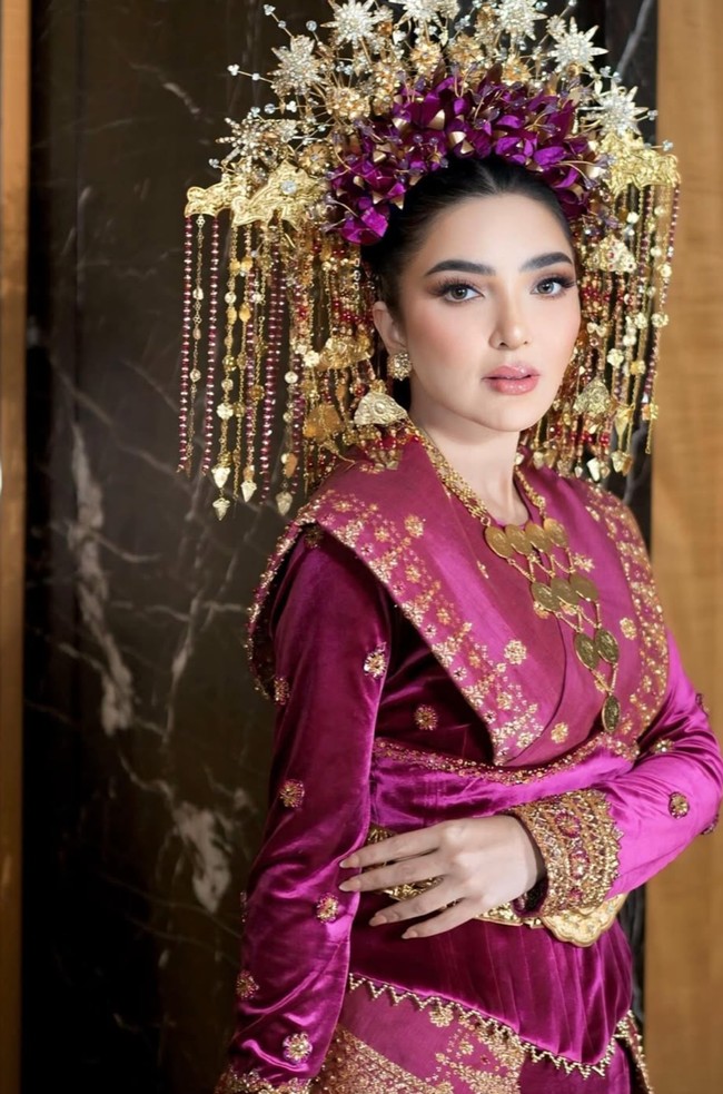 Ashanty melengkapi penampilannya dengan kalung emas bertingkat dan aksesoris lain yang senada. Aksesori tersebut tidak hanya mempercantik tampilan, tapi juga memperkuat nuansa adat Palembang. Foto: Instagram/@viennagallery