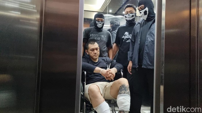 Buron kasus narkoba Andre Fernando The Doctor tiba di Bareskrim setelah ditangkap di Malaysia. Andre dibawa petugas menggunakan kursi roda. (Taufiq S/detikcom)