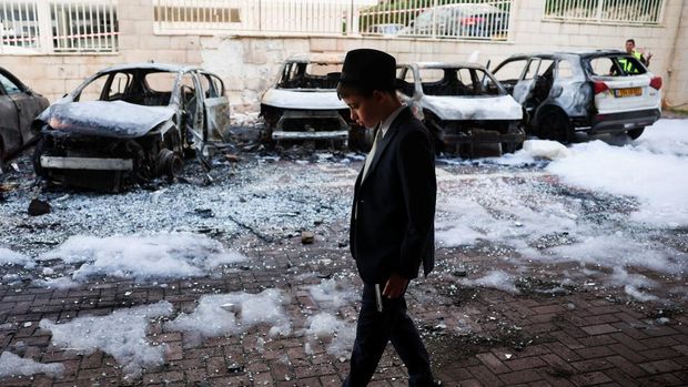 IRAN-CRISIS/ISRAEL Emergency personnel work next to burnt-out vehicles at an impact site, following a barrage of missiles launched from Iran, amid the U.S.-Israeli conflict with Iran, in Petach Tikva, Israel, April 6, 2026. REUTERS/Florion Goga